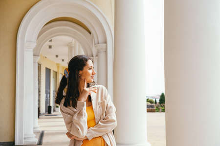 Portrait beautiful young woman weaing casual velvet jacket standing near column. Lifestyle mochrome portrait.の写真素材