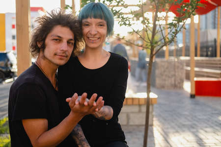 Young couple on a first date in a city park. Man touching woman's hand. Love and relationships concept.の写真素材
