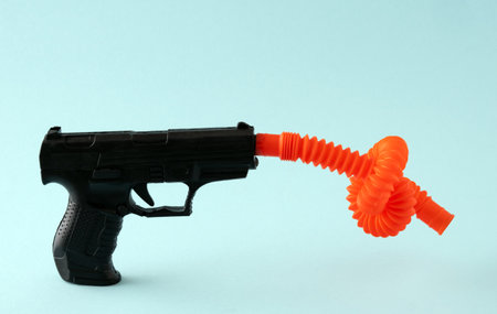 Pistol with tied barrel on blue background. No violence concept.の写真素材