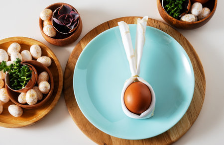 Top view flat lay egg with bunny ears on blue plate serving for easter celebration.