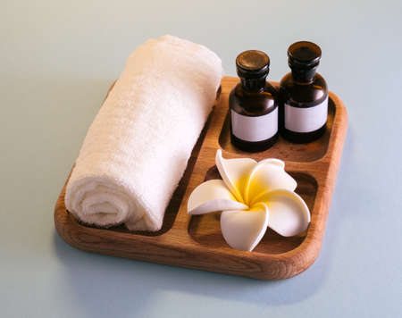 Still life towel and cosmetic products on a wooden tray brown background.の写真素材