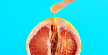 Close up grapefruit with dripping honey on blue background. Bikini zone hair removal concept.