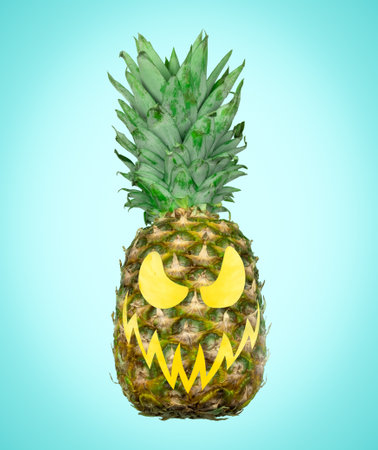 Pineapple with scary carved face on blue background. Creative minimal art Halloween poster.の写真素材