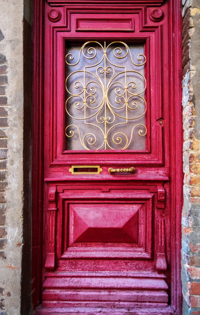 Old wooden painted red door with golden metal decor in Old Town of Tbilisi, Georgia.の写真素材