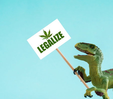 Cute dinosaur holding banner with legalize inscription on blue background.の写真素材