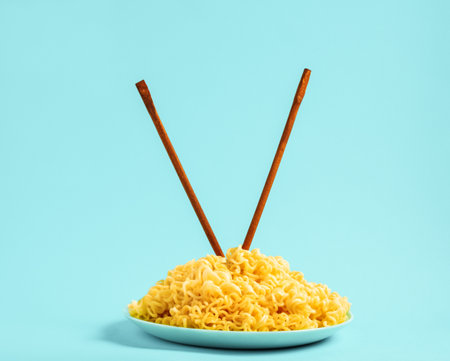 Egg noodles on blue plate with chopsticks on blue backgroundの写真素材