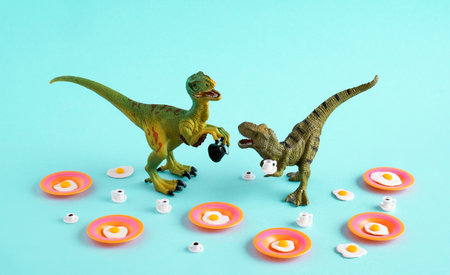 Green dinosaur with fried eggs and coffee cups on blue background.の写真素材
