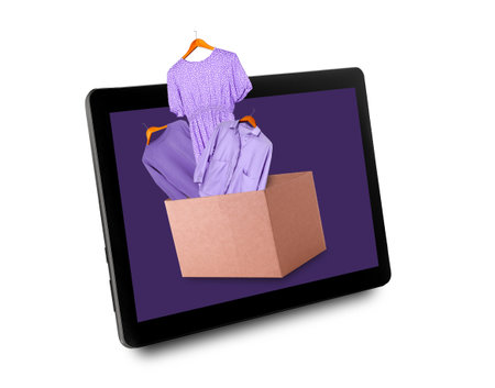 Clothes in cardboard box on digital tablet screen. Online shopping concept.の写真素材