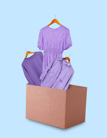 Clothes in cardboard box on blue background.の写真素材
