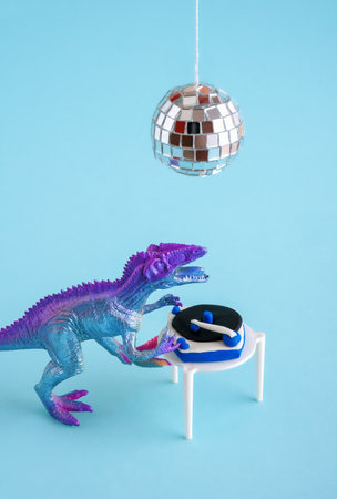 Cute blue and violet dinosaur toy holding listen vinyl on vinyl record player on blue background.の写真素材