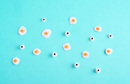Top view flat lay miniature fried eggs and coffee cups on pastel blue background.の写真素材