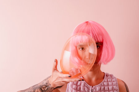 Beautiful young woman with pink hair holding bubble. Generation z. Mental health concept.の写真素材