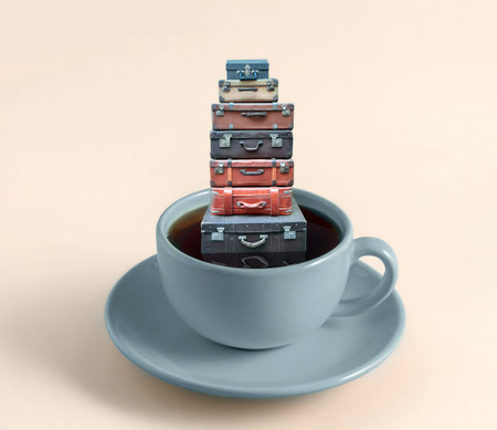 Stack of old vintage suitcases floats in coffee mug. Travel concept.の写真素材
