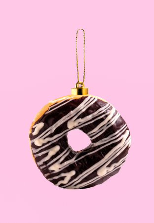 Chocolate donut Christmas tree toy on pink background. Creative collage.の写真素材