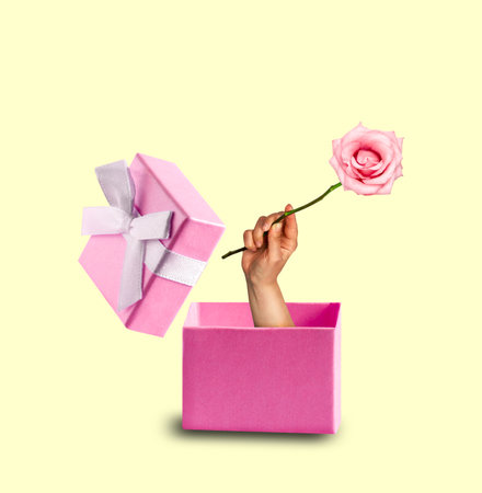 Art collage with gift box and hand holding rose on yellow background. Minimal art card.の写真素材
