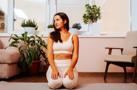 Young beautiful woman sits on yoga mat.の写真素材