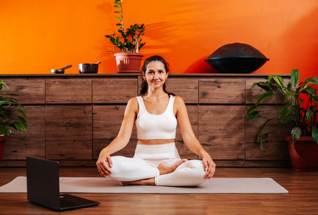 Beautiful woman in lotus position doing yoga online.の写真素材