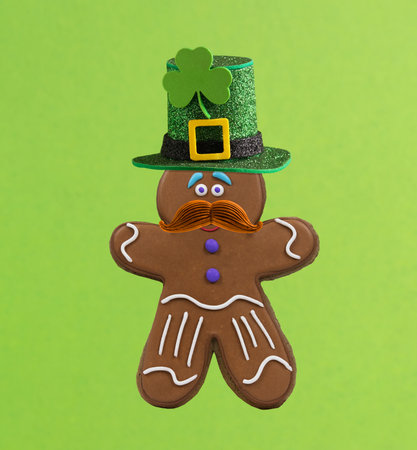 Cute gingerbread man with red mustache and green hat. Postcard for St. Patrick's Day.の写真素材