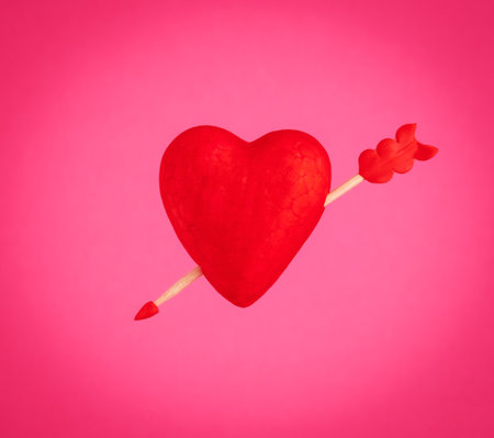 Red heart with arrow on pink background.の写真素材