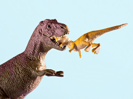 A big dinosaur is trying to eat a small one.の写真素材