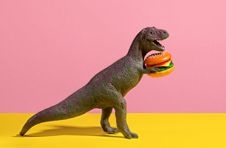 Happy dinosaur holding burger on pink and yellow background.