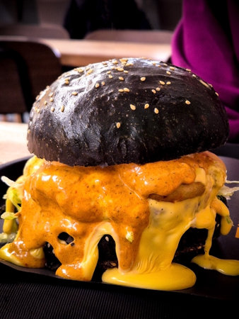 Close up burger with dripping cheese sauce. Fast food. Mobile photography. Real food.の写真素材