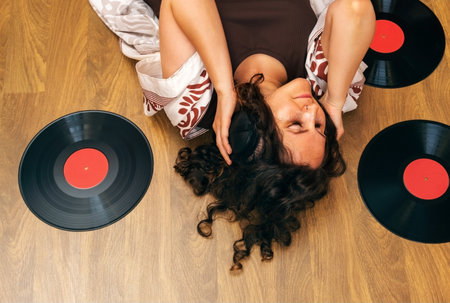 Top view woman lying on the floor with headphones and listening old vinyl records.の写真素材