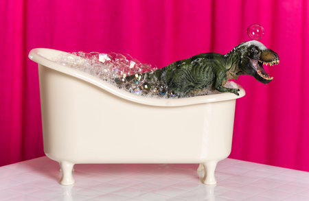 Cute green dinosaur in bathroom against pink curtain background