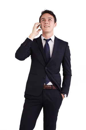 A young caucasian male businessman looking happy holding a mobile phone looking away from camera.の写真素材