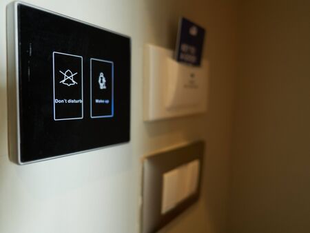 A don't disturb sign. The sign is a digital switch. The panel is black in color, mounted on a wall.の写真素材