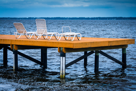 wooden deck with white chairs over the st johns riverの写真素材