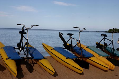 bicyle peddle boats on the beach waiting to be rentedの写真素材
