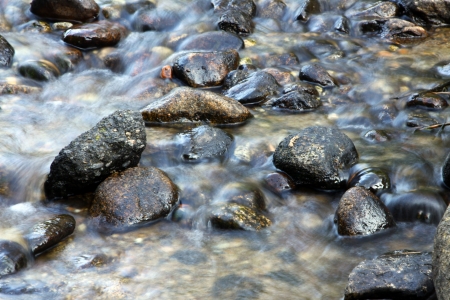Water flowing over rocks in a streamの写真素材