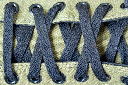 Closeup of crossed black shoelaces on a sneakerの写真素材