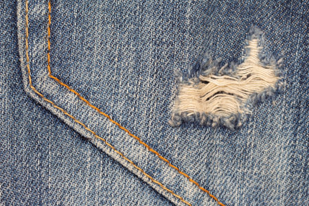 close up of torn denim jeans pocket