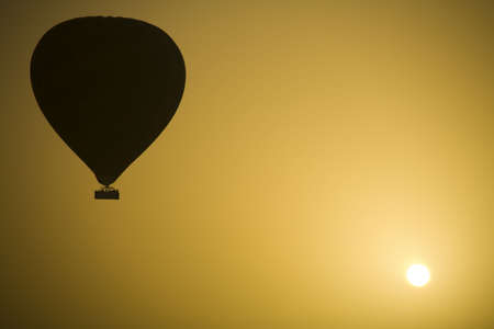 A hot air Balloon backlit by the rays of the morning Sun.の写真素材