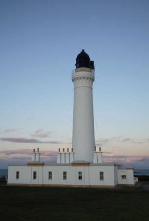 A white lighthouse at dusk and a blue sky.の写真素材