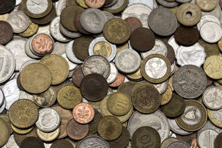 Loads of coins from around the world, isolated.の写真素材