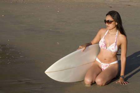An asian surfer woman, in her 20's on the beach wearing a bikini.の写真素材