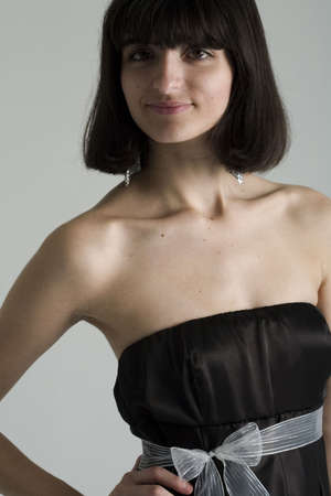 An 18 year old exotic brazilian model, with short dark hair, a young looking face and a skinny body. This was shot in a studio and she's weariing a black, strapless dress.の写真素材