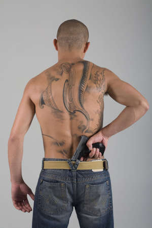A young, muscular brazilian man in a studio shot on a gray background.の写真素材