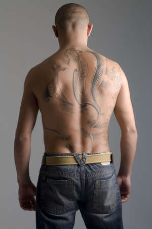 A young, muscular brazilian man in a studio shot on a gray background.の写真素材