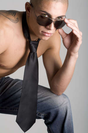 A young, muscular brazilian man in a studio shot on a gray background.の写真素材