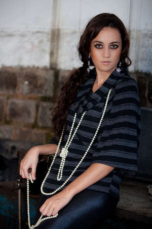 A young brazilian female model shot in a dirty auto repair shop.の写真素材