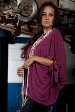 A young brazilian female model shot in a dirty auto repair shop.の写真素材