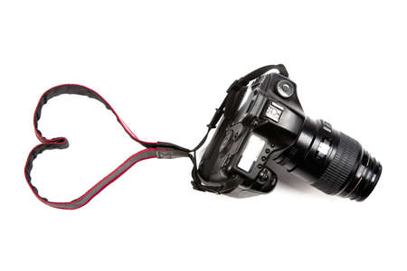 A digital camera isolated on a white background, where the strap makes a heart sign. Perfect for photography professionals and  lovers!の写真素材