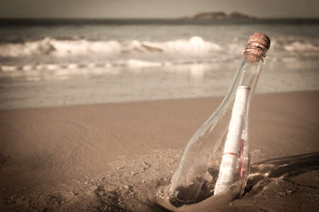 A message inside a glass bottle, washed up on a remote beach.の写真素材