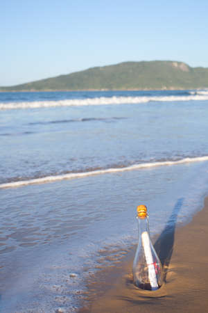 A message inside a glass bottle, washed up on a remote beach.の写真素材
