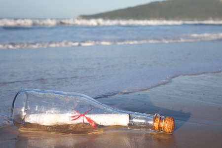 A message inside a glass bottle, washed up on a remote beach.の写真素材
