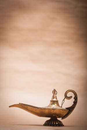 A magic genie lamp, isolated on a sand color background, in a studio shot.の写真素材